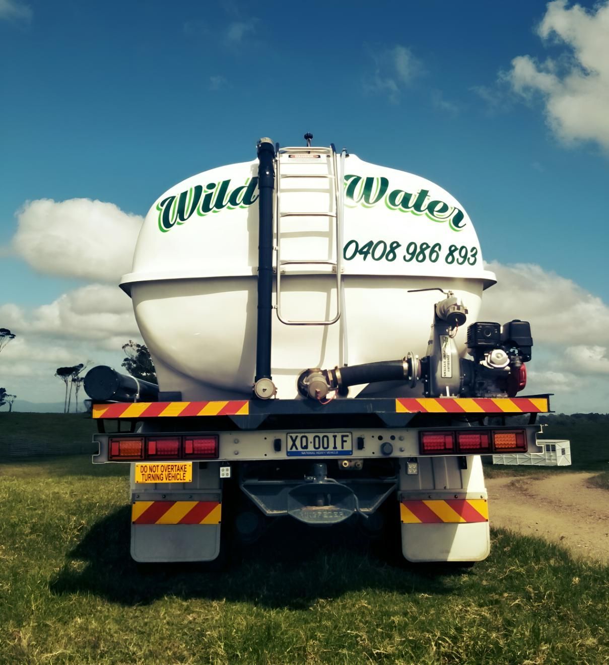 A White Wild Water Truck is Parked in a Grassy Field — Wild Water Delivery in Maleny, QLD