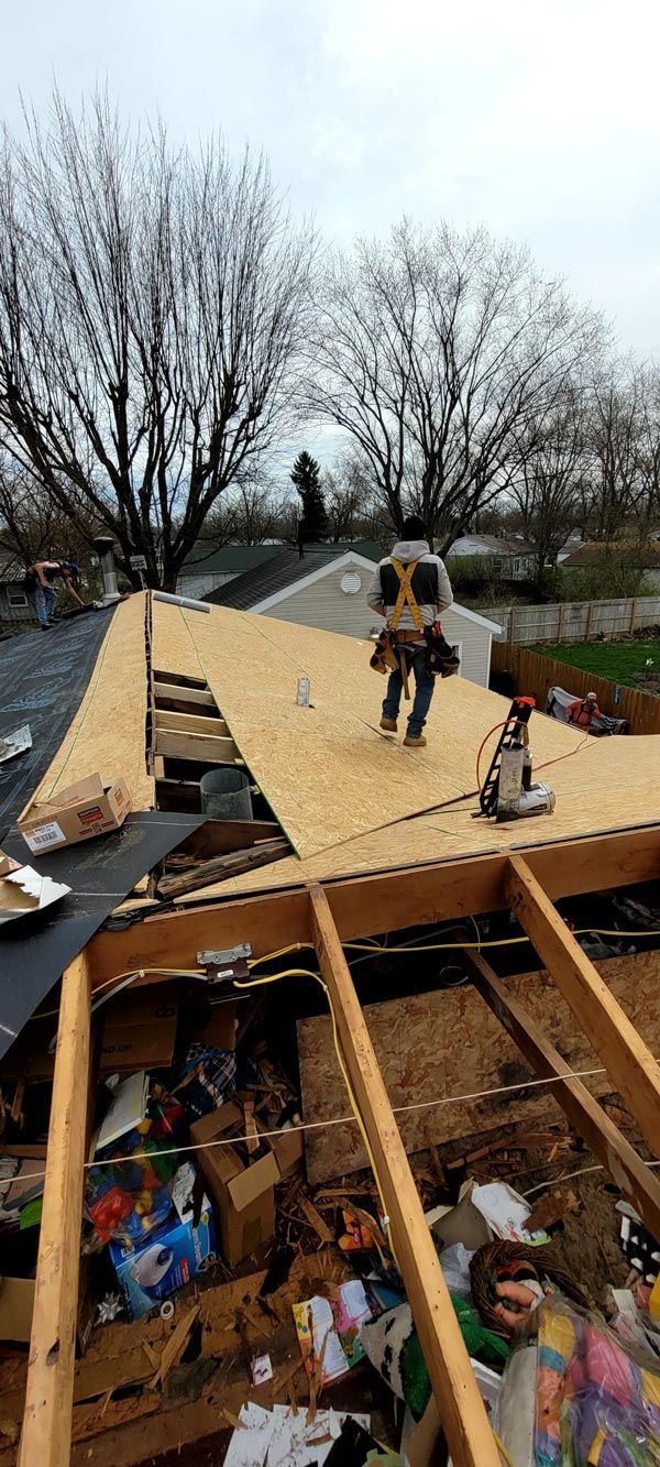 A couple of men are standing on top of a roof.