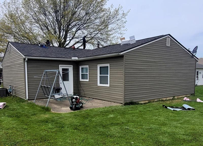 A small house with a swing set in the backyard.