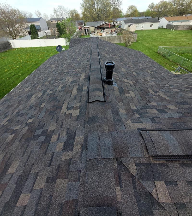 An aerial view of a roof with shingles and a chimney.