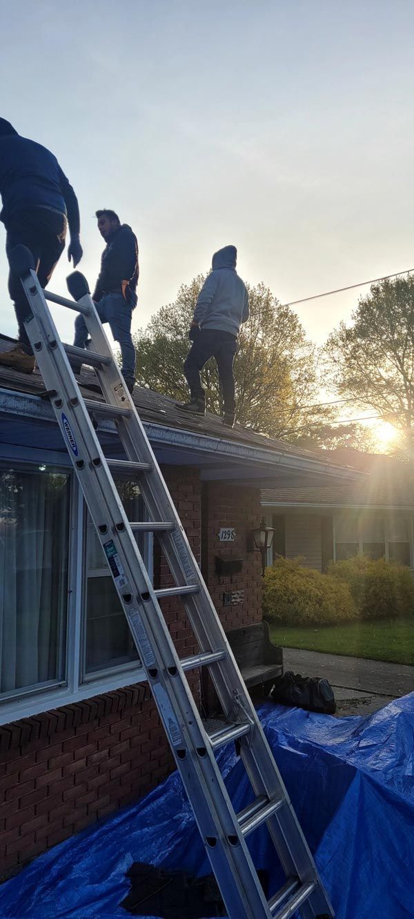 A group of men are working on the roof of a house.