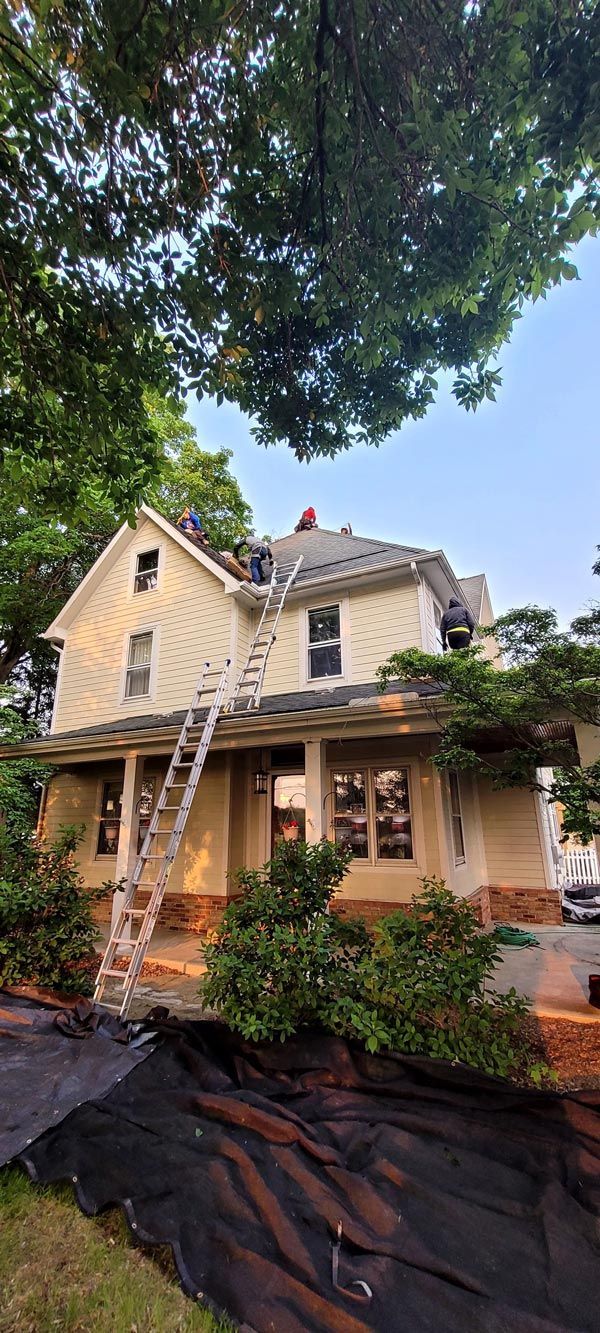 Two men are working on the roof of a big house.