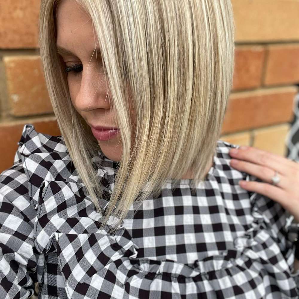 A Woman With Blonde Hair is Wearing a Black and White Plaid Shirt — Innovative Hair Salon in Gosford, NSW