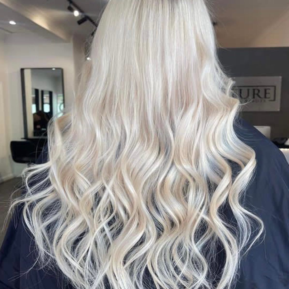 A Woman With Long White Hair is Sitting — Innovative Hair Salon in Gosford, NSW