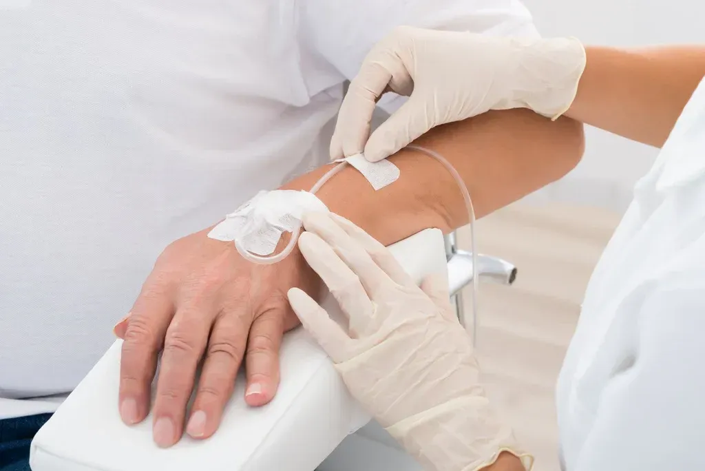 Healthcare worker inserting an IV line into a patient’s arm