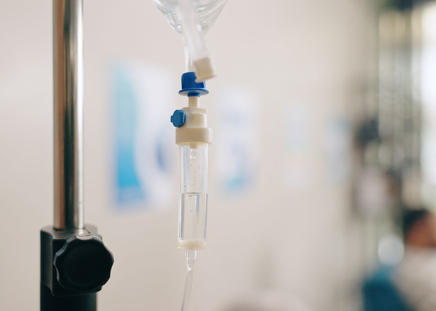 IV drip hanging from a metal stand with a blurred hospital background