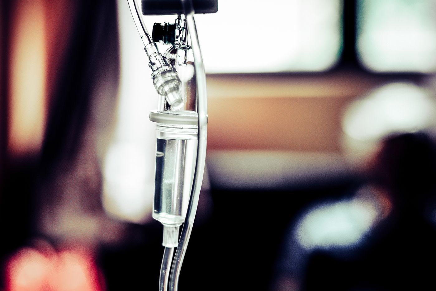 IV drip bag hanging beside a window with blurred background