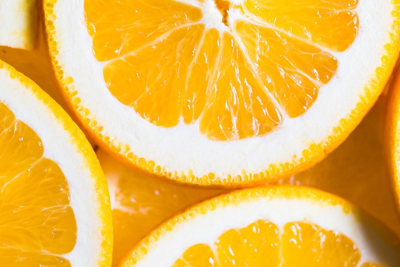 Close-up of sliced oranges with bright orange flesh and white rind arranged in a colorful pattern