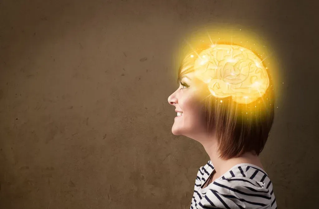 Profile of a person with a glowing brain illustration inside the head, against a brown background