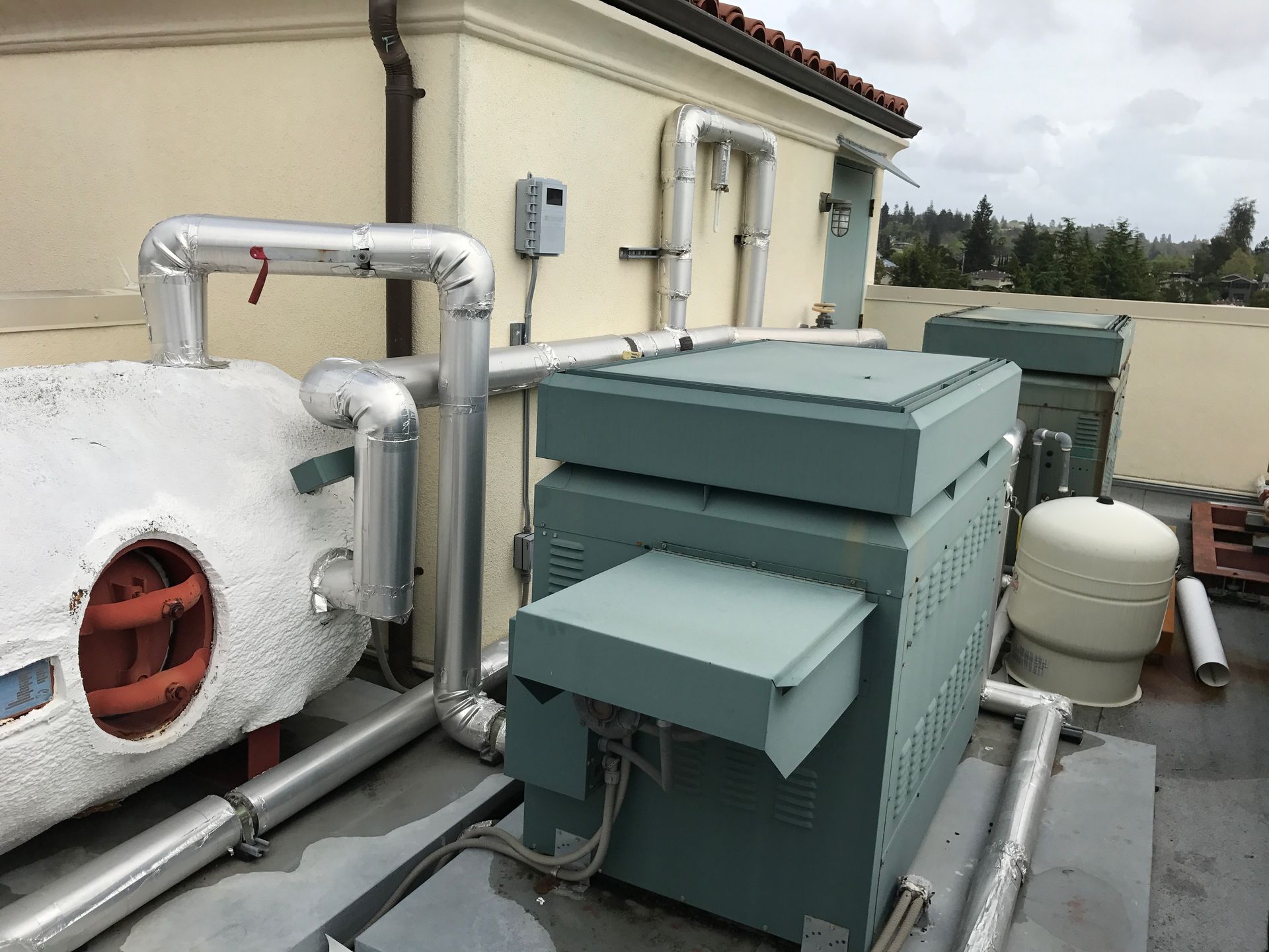A rooftop of a building with a lot of pipes coming out of it