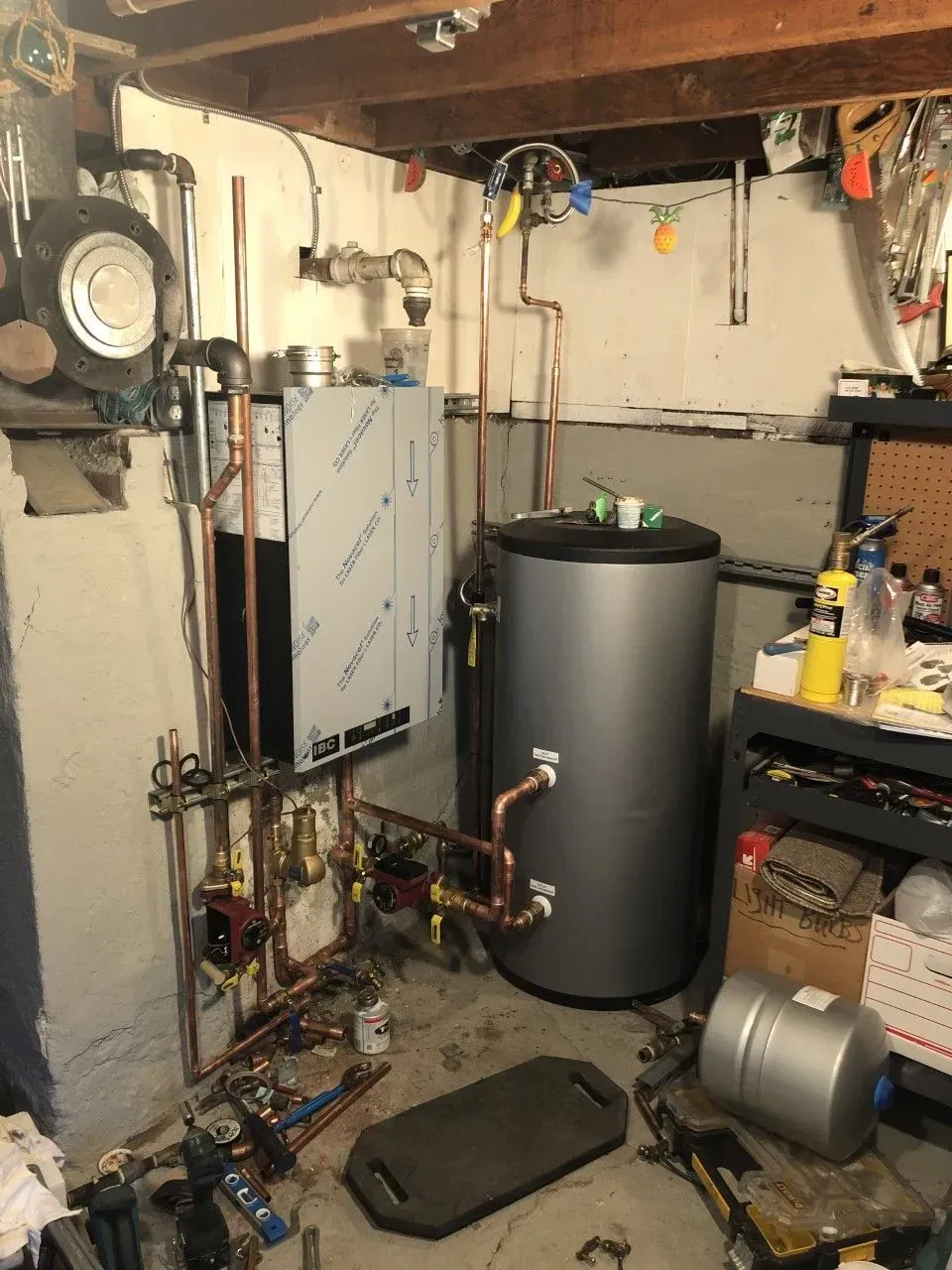 A room with a water heater and a bunch of pipes