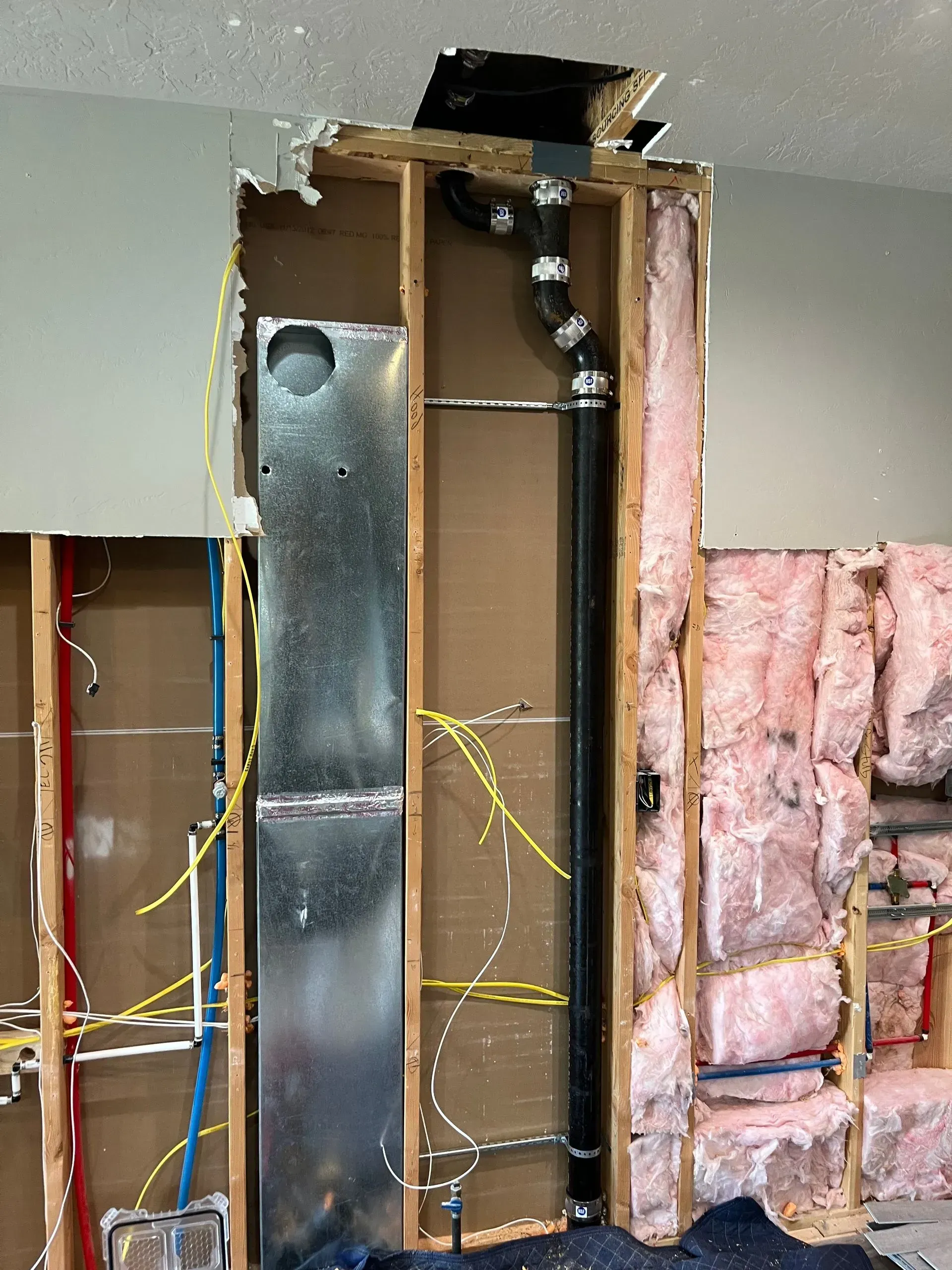 A pipe is coming out of a hole in a wall.