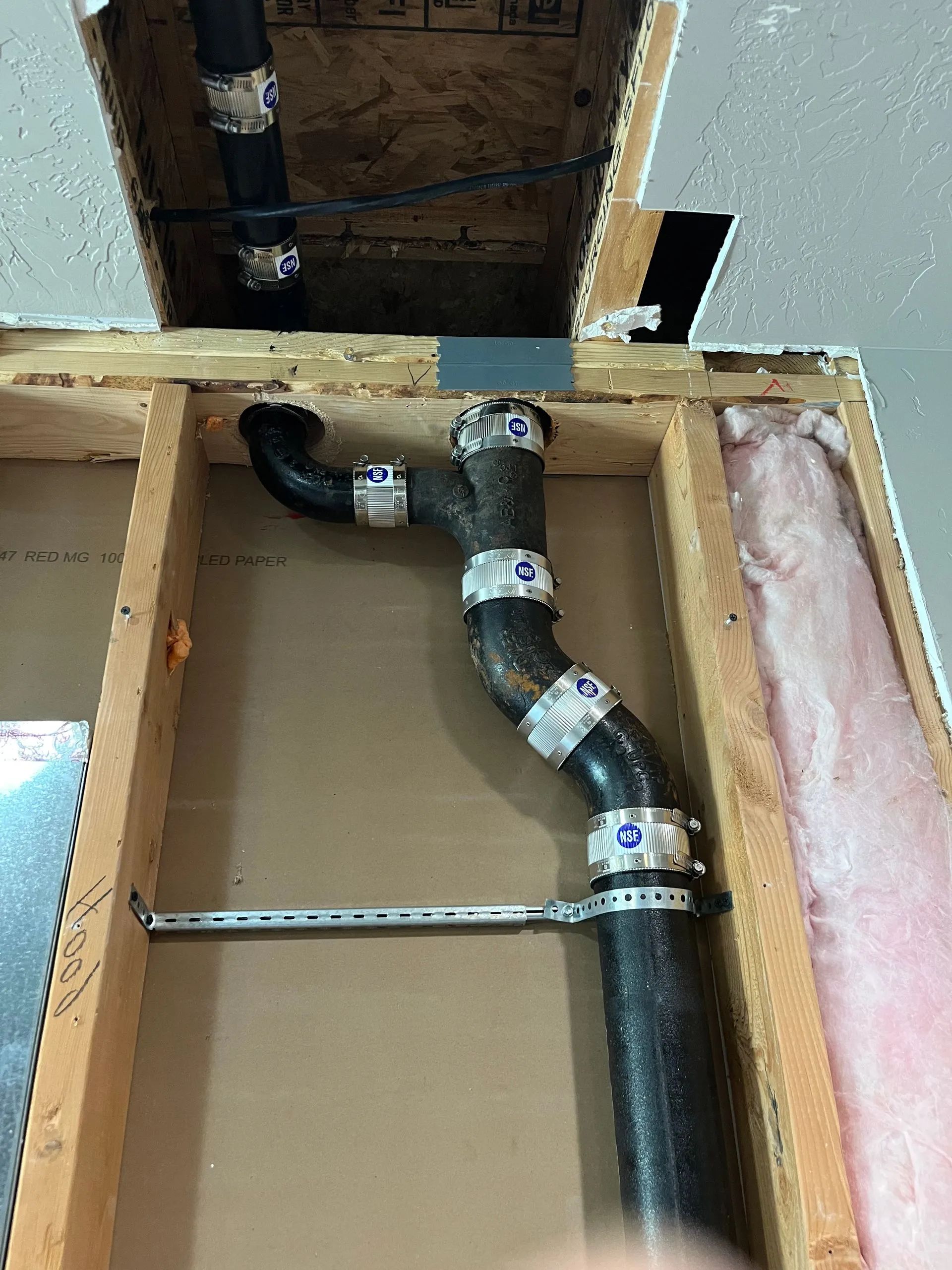 A pipe is being installed in a wooden box.