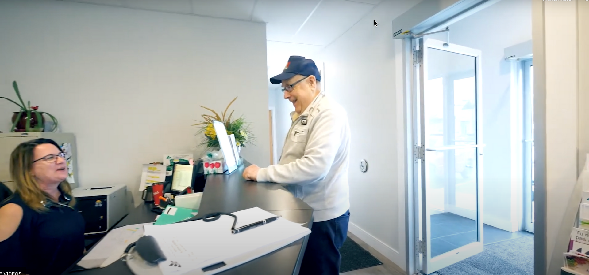 Un homme debout à la réception d'un bureau.
