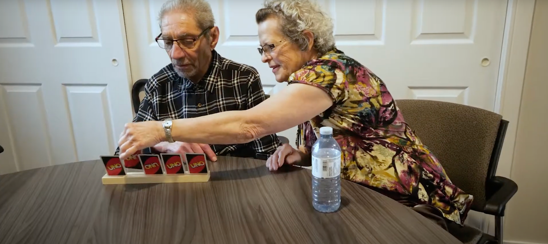 Un homme et une femme sont assis à une table et jouent à un jeu.