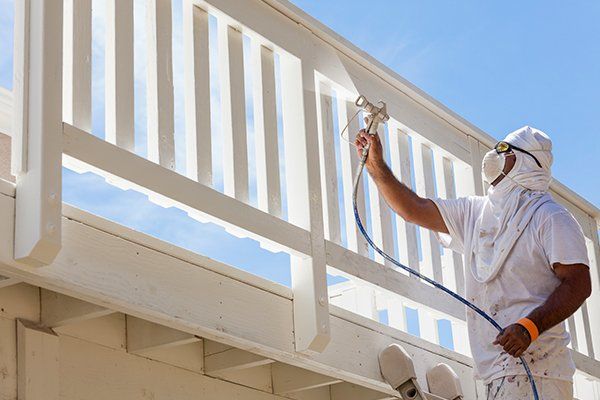 House painter spray painting a deck of a home — La Selva Beach, CA — J's Custom Painting