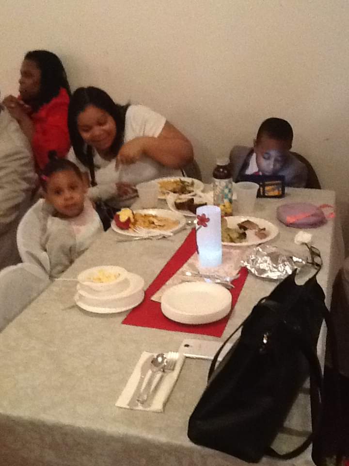 a group of people are sitting at a table with plates of food