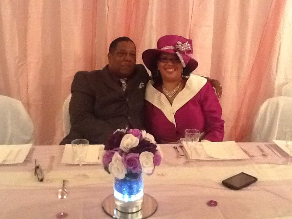 a man and a woman are posing for a picture at a table