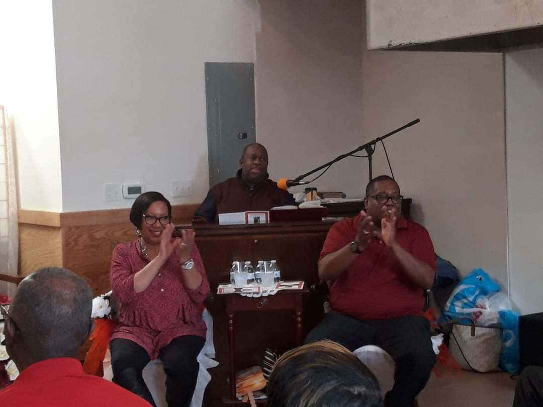 a group of people sitting in front of a piano applauding