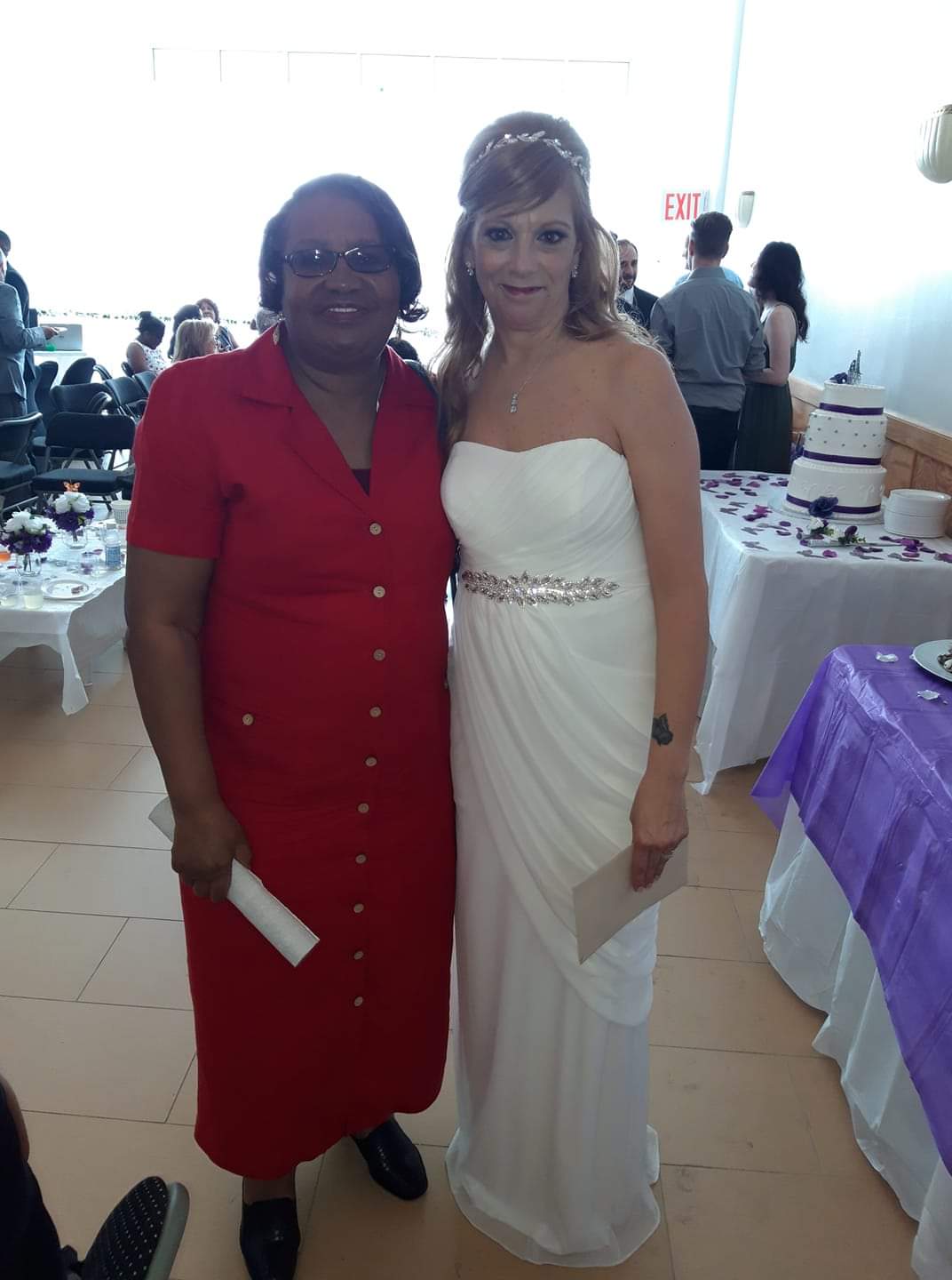 a woman in a red dress stands next to a woman in a white dress