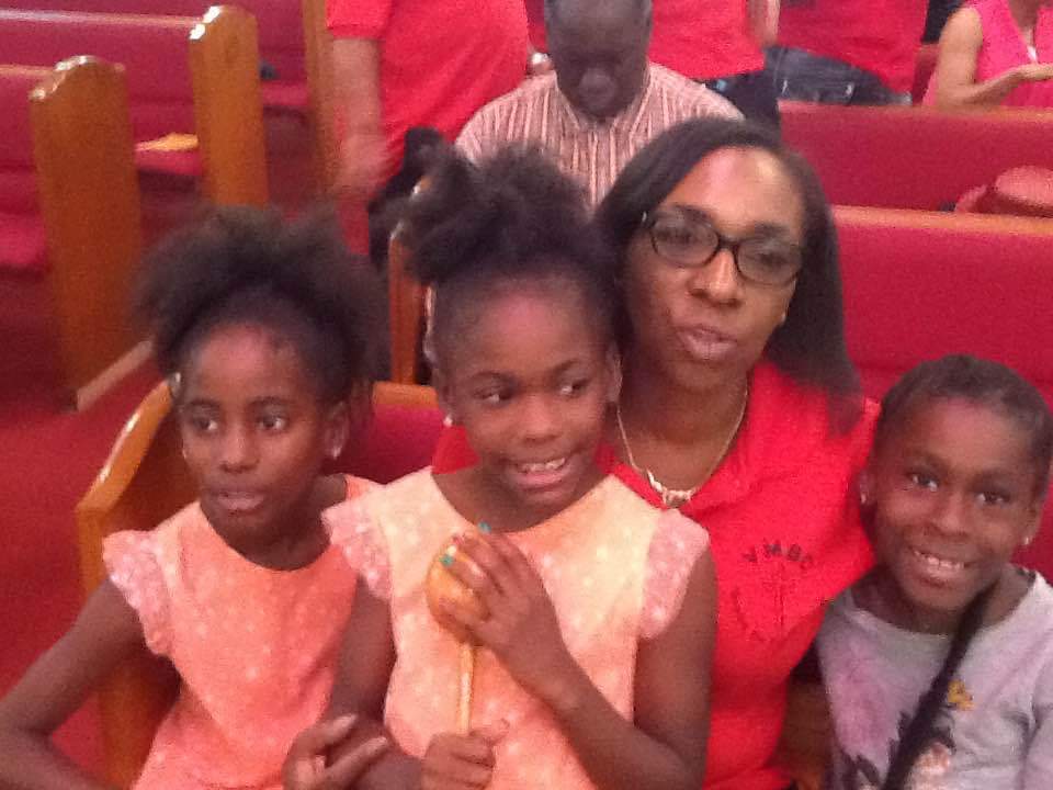 a woman and three children are posing for a picture in a church .
