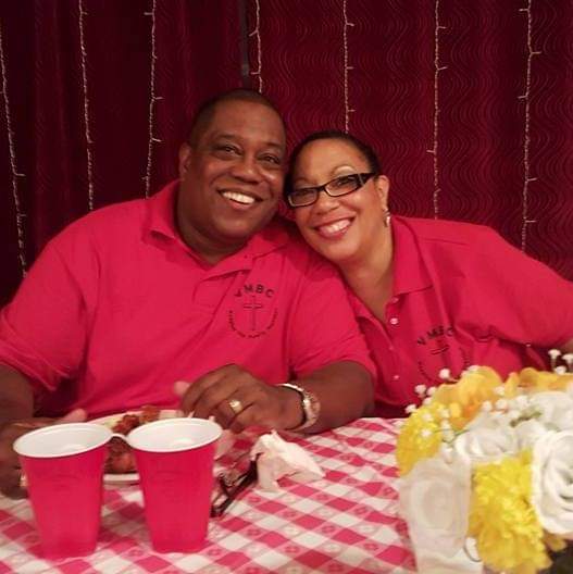 a man and a woman are sitting at a table with red cups