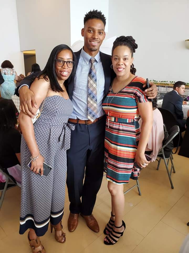 a man in a suit and tie is posing for a picture with two women .