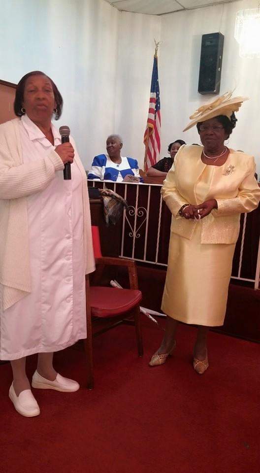 two women are standing next to each other in a room holding microphones .