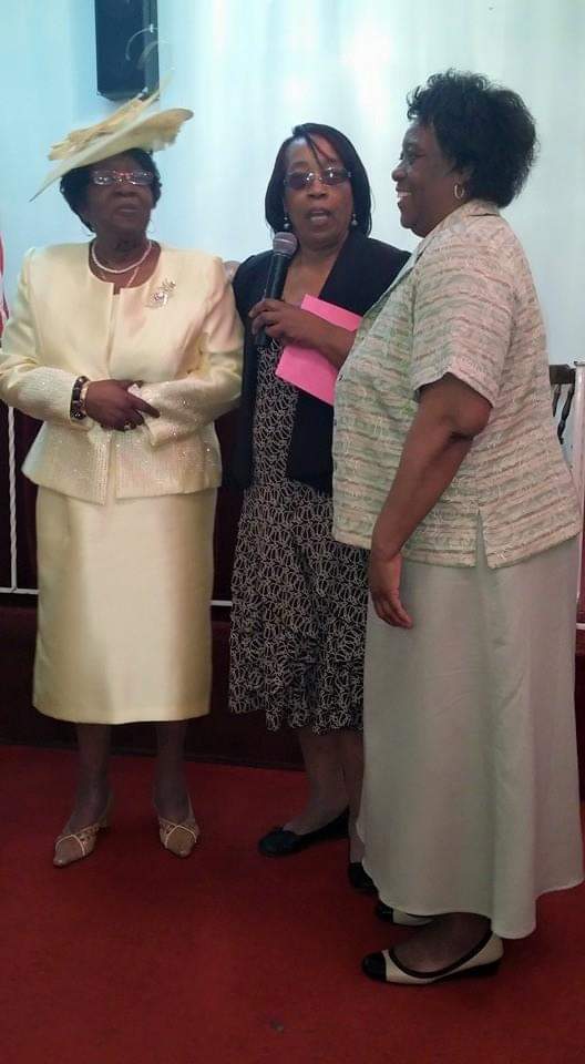 three women are standing next to each other on a red carpet .