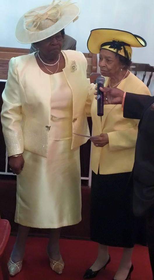 two women in yellow suits and hats are standing next to each other