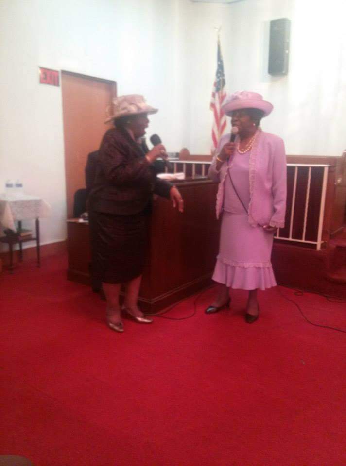 a woman in a purple dress is speaking into a microphone