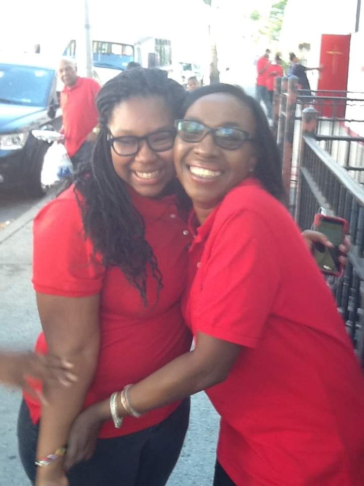 two women wearing red shirts are hugging each other