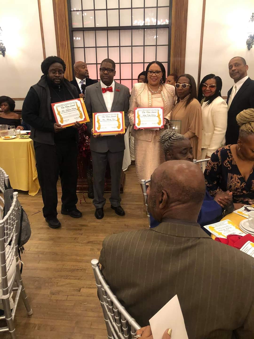 a group of people are standing in a room holding certificates .