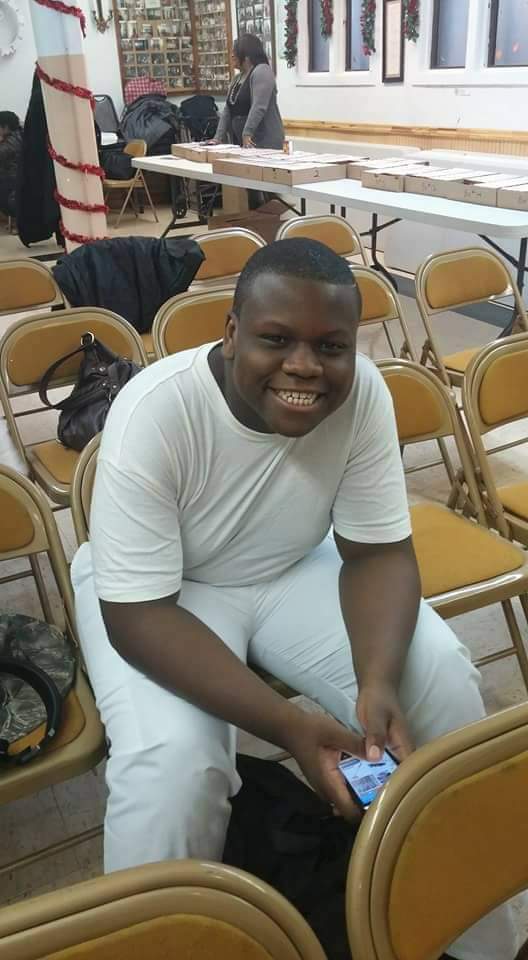 a man is sitting in a chair holding a cell phone and smiling .