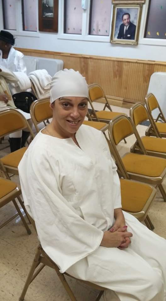 a woman in a white robe is sitting in a chair