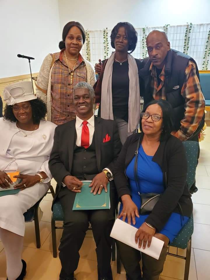 a group of people are posing for a picture while sitting in chairs .