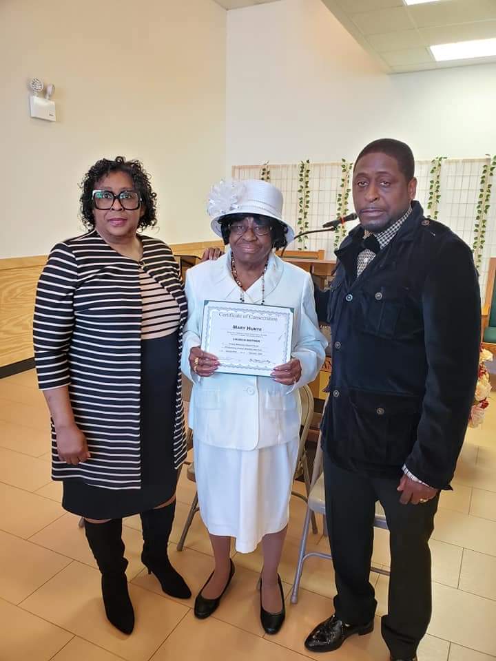 a man and two women are standing next to each other holding a certificate .