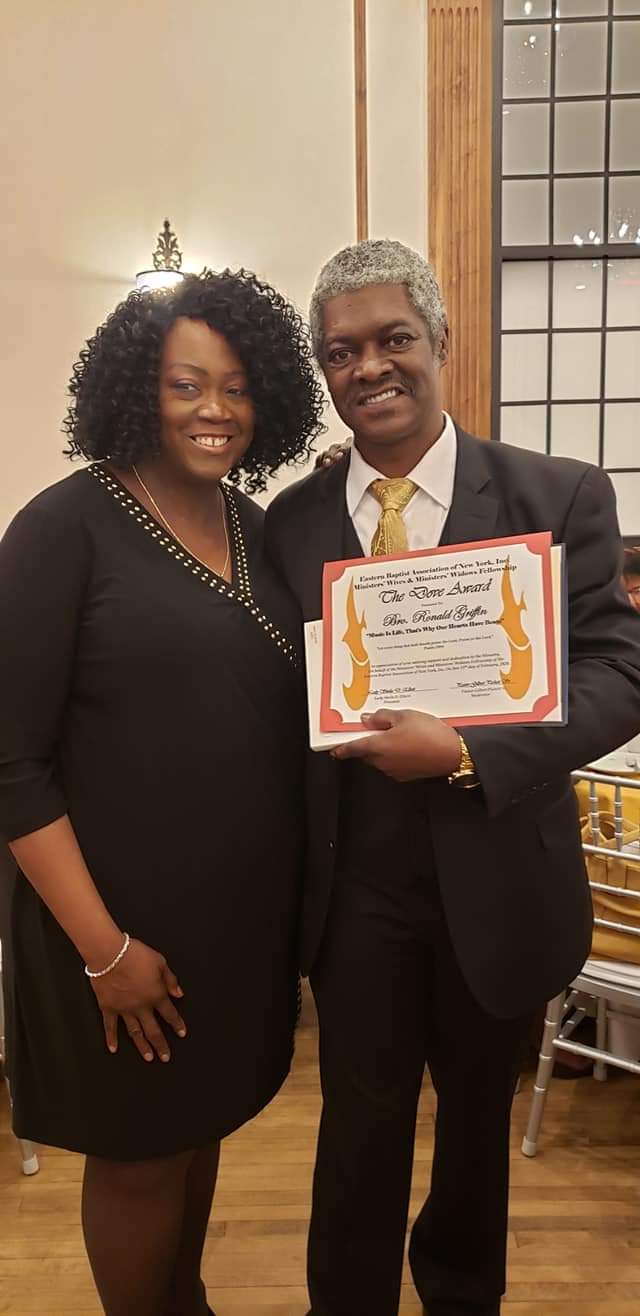 a man and a woman are standing next to each other holding a certificate .
