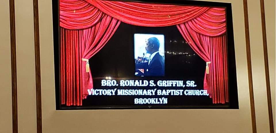 a large screen with a picture of a man on it is hanging on a wall .