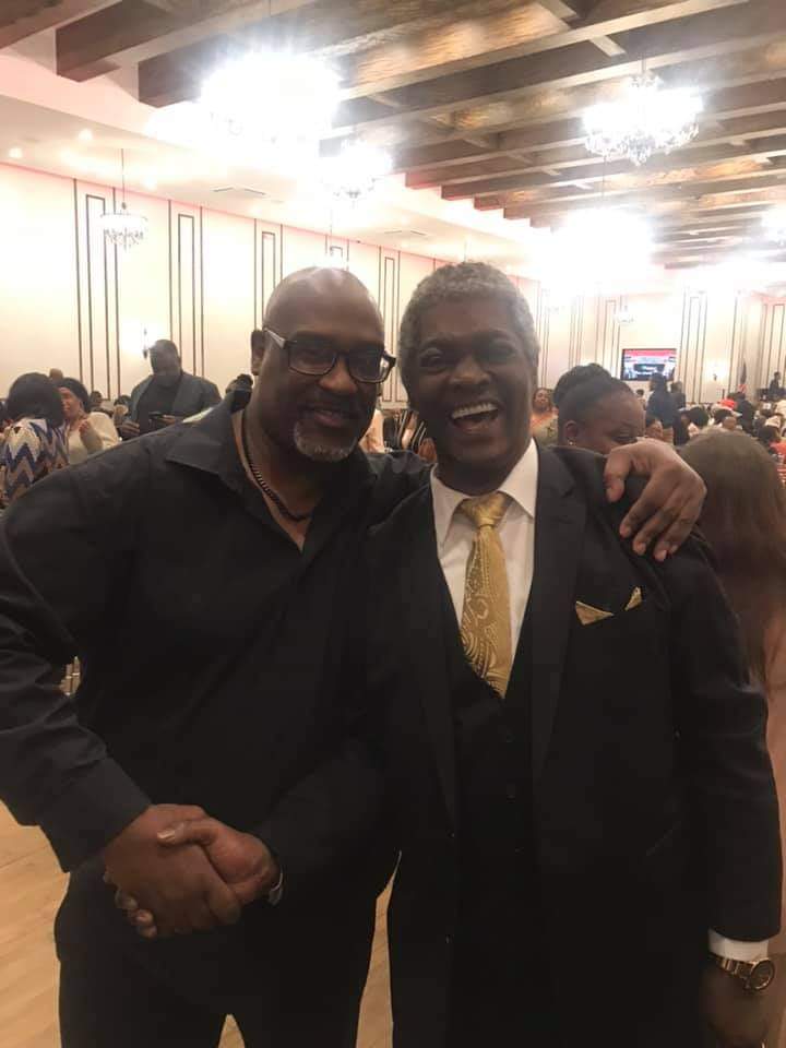 two men are posing for a picture together in a room .