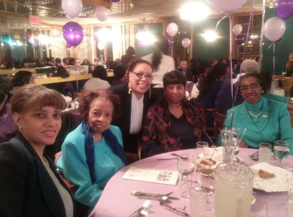 a group of women are posing for a picture at a dinner table