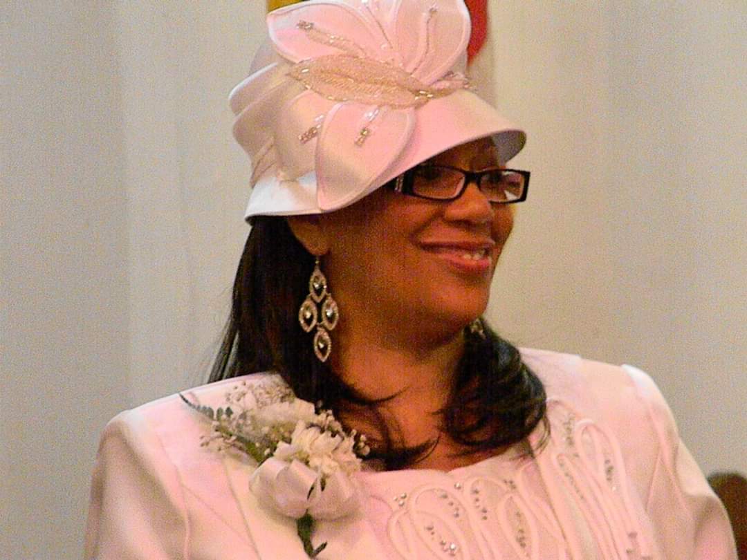 a woman wearing a white hat and glasses is smiling .