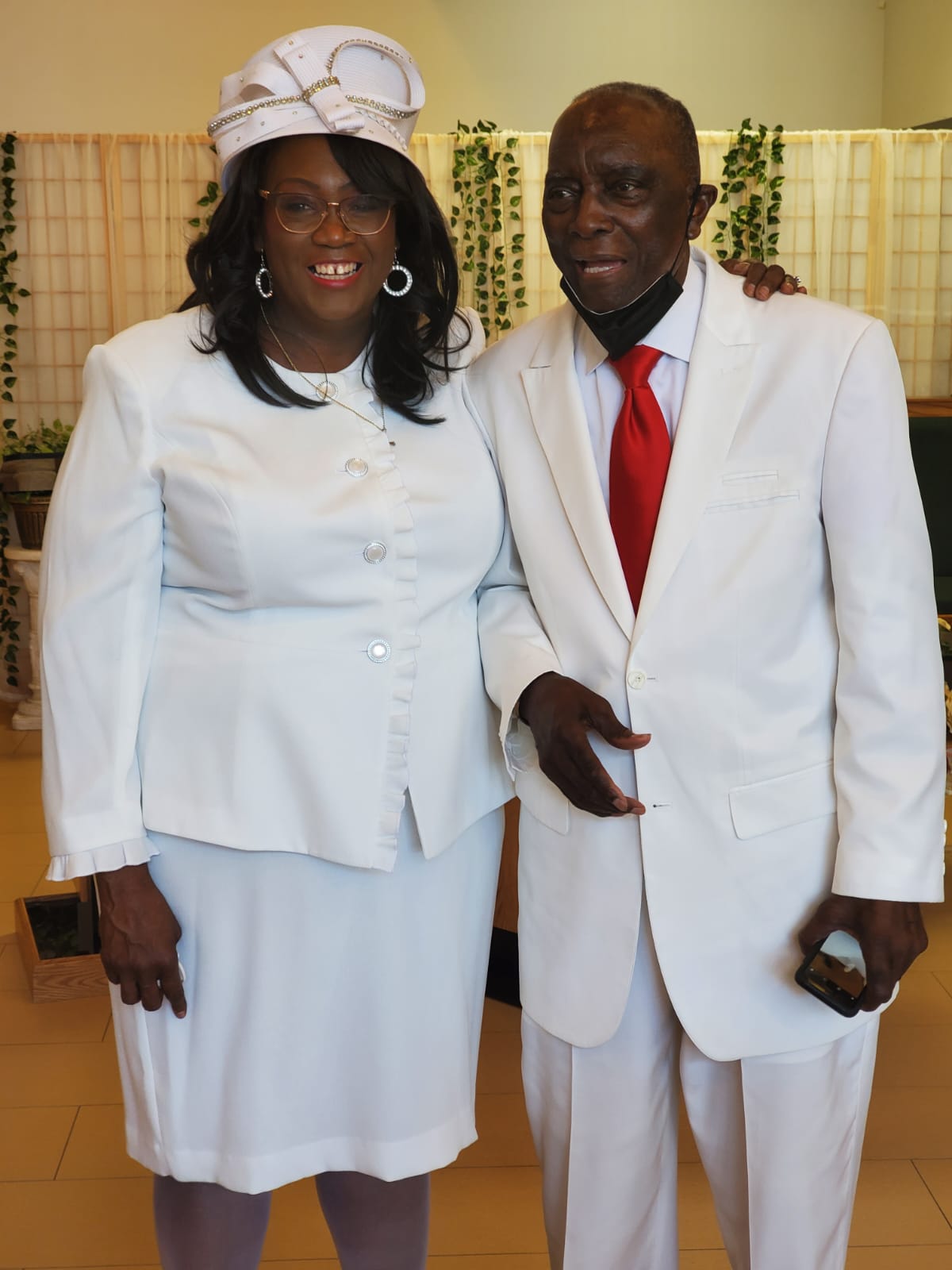 a man and a woman in white suits pose for a picture