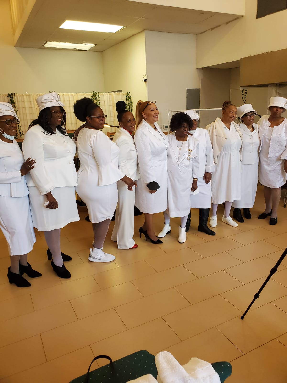 a group of women in white dresses are standing in a room