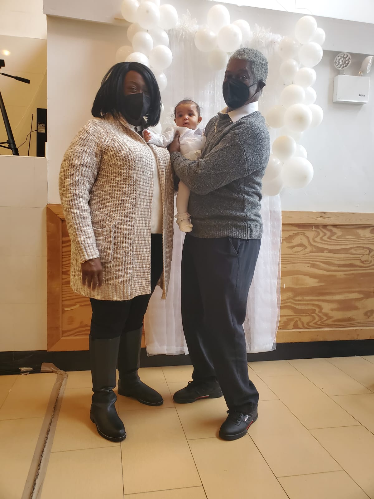 a man and a woman are standing next to each other holding a baby .