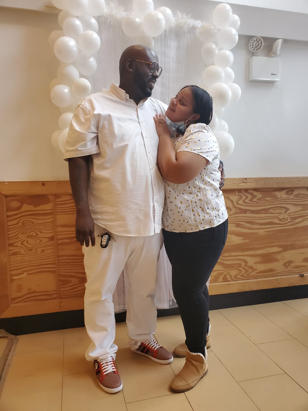 a man and a woman are standing next to each other in front of balloons .