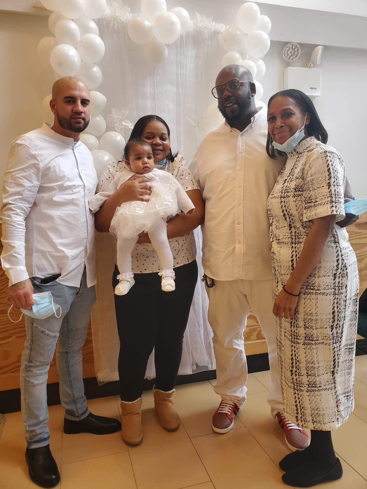 a group of people standing next to each other holding a baby .