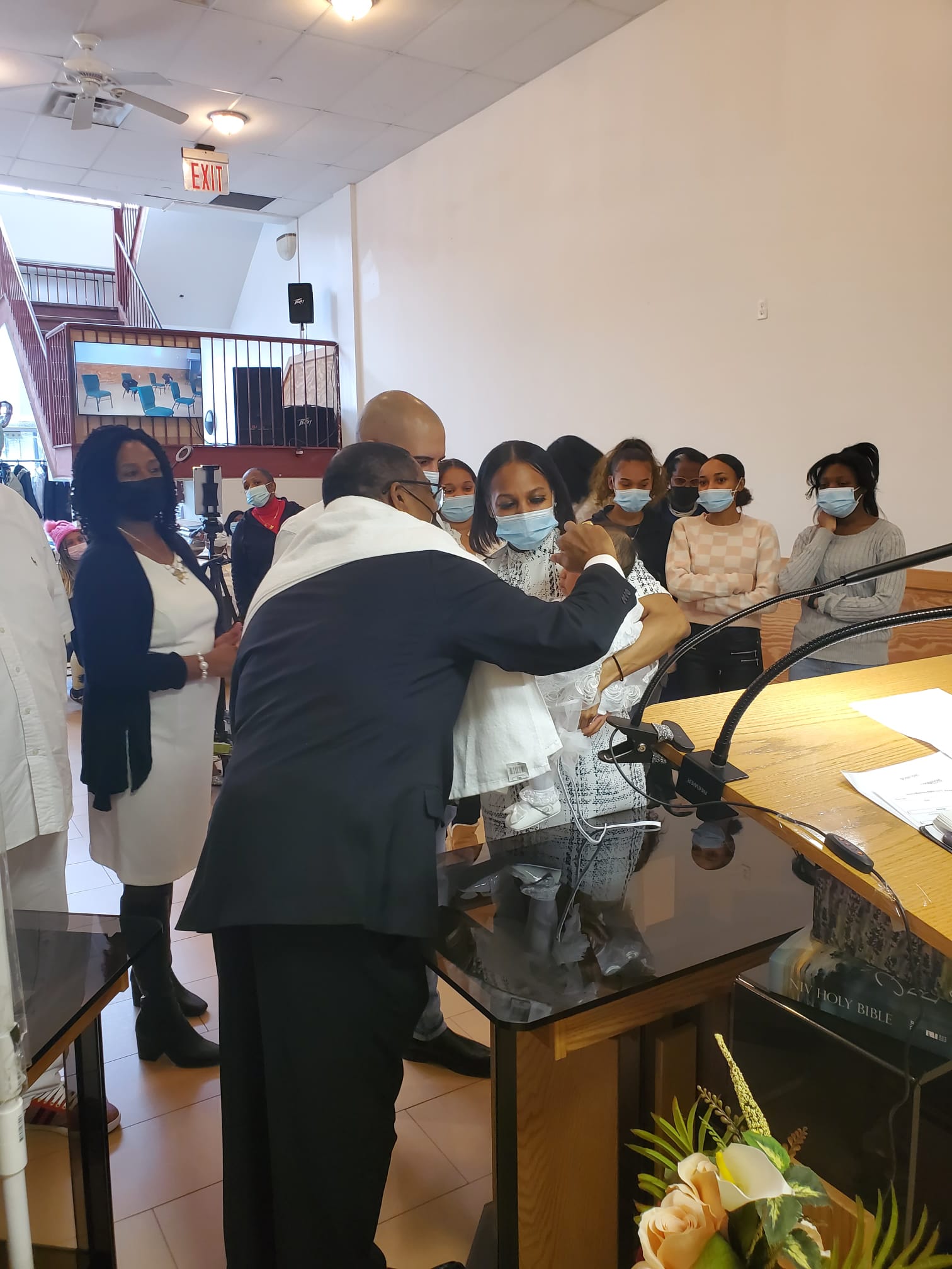 a group of people wearing face masks are standing around a podium .