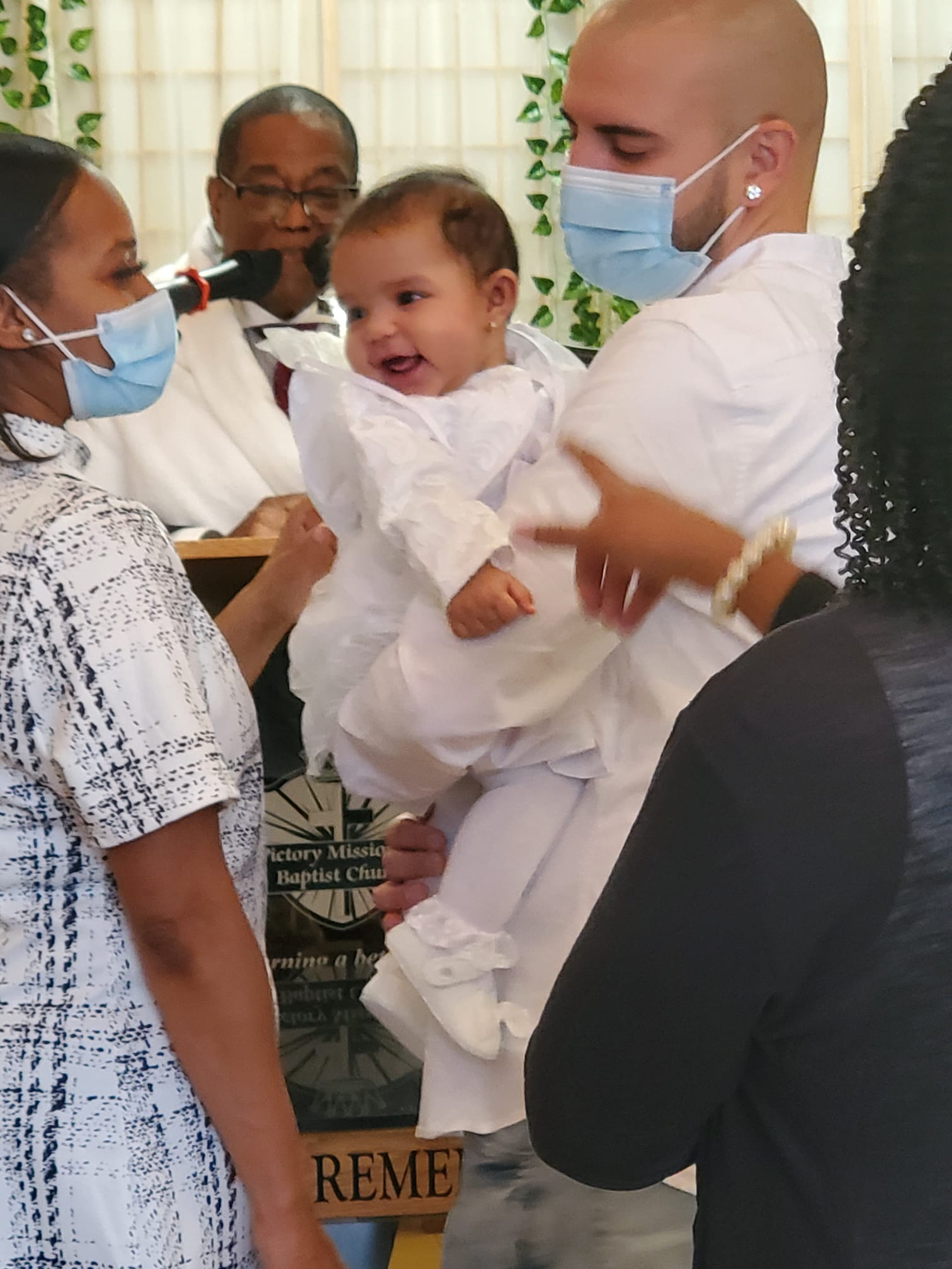 a man wearing a mask is holding a baby