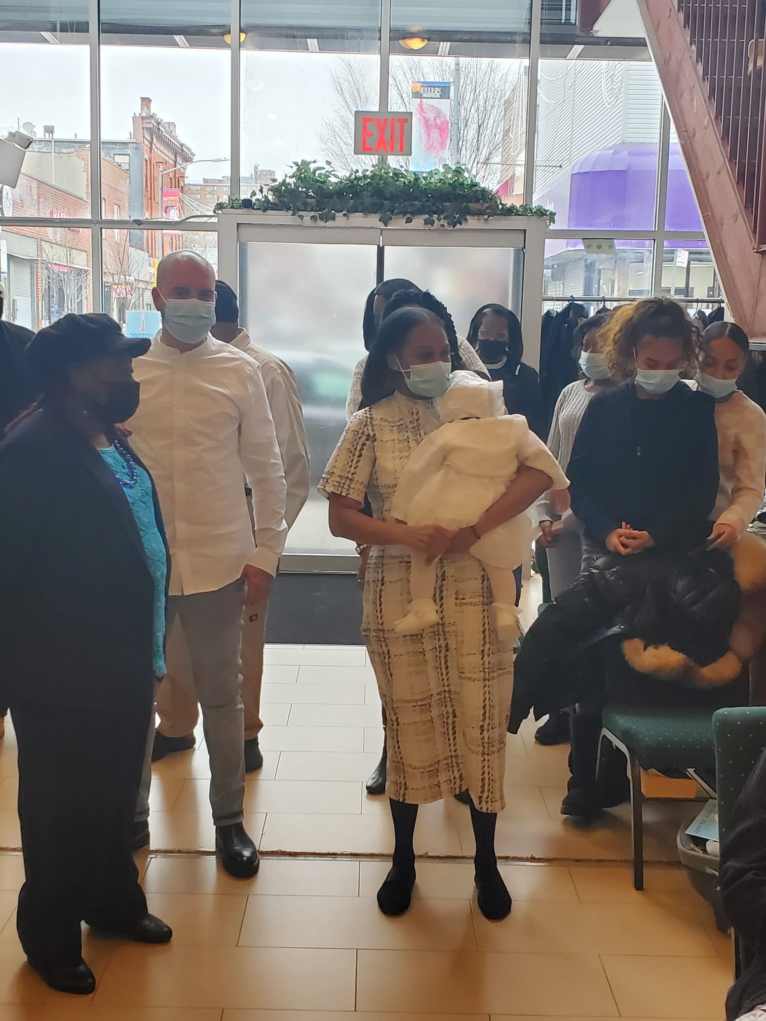 a group of people wearing face masks are standing in a room .